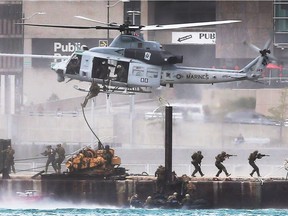 Marines rappel from a helicopter on to a barge during the United States Marine Air-Ground Task Force Show held over the Detroit River on Thursday, September 7, 2017.