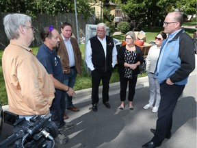 Provincial NDP Leader Andrea Horwath, third from the right, along with NDP MPPs Taras Natyshak, Percy Hatfield and Lisa Gretzky, and Windsor Mayor Drew Dilkens, far right, speak with a Windsor resident, left, and a contractor, second from left,   during a tour of the flood zone in Riverside on Sept. 7, 2017.