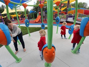 Rachel Trella, left, and her four-year-old triplets Olivia, Hailey and Ava try out the Play McGivney facility on Wednesday. The yard between the John McGivney Children's Centre and Hotel-Dieu Grace Healthcare has been transformed into an accessible outdoor space for those of all ages.