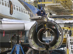 An employee from Premier Aviation works on the engine of a Boeing 737 passenger jet on Nov. 28, 2016 in Windsor.
