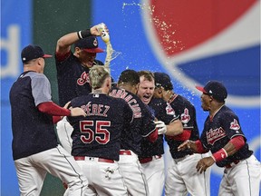 Cleveland Indians' Jay Bruce, centre, celebrates with teammates after Bruce drove in the winning run with a double off Kansas City Royals relief pitcher Brandon Maurer during the 10th inning of a baseball game, Sept. 14, 2017, in Cleveland. The Indians won 3-2.