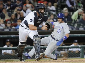Kansas City Royals' Whit Merrifield slides safely into home plate as Detroit Tigers catcher James McCann waits for the throw on a Lorenzo Cain single in the seventh inning of a baseball game in Detroit, Sept. 6, 2017.
