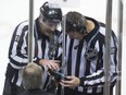 In this Dec. 3, 2015,  photo, linesmen Don Henderson, left, and Mike Cvik look at a monitor during a coach's challenge by the Vancouver Canucks of an onside call on a goal by Dallas Stars' Patrick Sharp during the third period of an NHL hockey game in Vancouver. The call on the ice stood and the goal was allowed. The NHL has a clear message to coaches this season: Don't challenge an offside call unless you're really, really confident it was wrong.