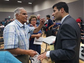 South Windsor resident Mohammad Khan, left, speaks to Windsor city councillor Fred Francis regarding recent flooding during a Ward 1 public meeting on Sept. 12, 2017, at South Windsor Arena.