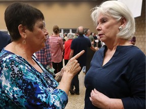 Riverside resident Linda Lavigne, left, chats with Coun. Jo-Anne Gignac Thursday night during at a Ward 6 public meeting at the WFCU Centre. The main focus of discussion was the record flooding in the area. The Riverside ward — between Pillette and Little River roads — were hit particulary hard by the storm.