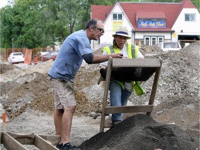 Auto mechanic Nick Papadatos inspects possible artifacts with Shelley Birch, a Caldwell First Nation archeology monitor during a dig next to his business near the Sandwich Street roundabout construction project on Oct. 4, 2017. While supportive of the search for historic artifacts, he said he'll be happy when the dig concludes and the roundabout is finished.