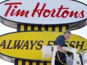 Bob Valliquette of WHC Construction installs new LED lighting inside the Tim Horton's sign at Tecumseh Road East and Howard Avenue.