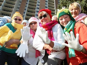 Members of the Keeping Kids Warm knitting group — Pat Williams, front left, Carol Renaud, Lynn Robertson, Val Taylor and Marilyn Myers, right, along with Denise Meloche, Sandy McCloskey and Linda Seeger, behind — model some of their knitted items outside Solidarity Towers on Monday. The winter wear will be donated to local children.