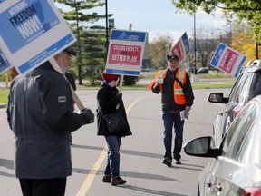 Vehicles and students are delayed momentarily at a picket line set up by striking members of OPSEU Local 138 at Cabana Road West entrance to St. Clair College's main campus on Oct. 16, 2017.