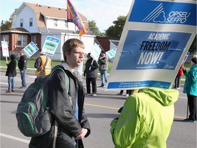 St. Clair College student Branden Brebric, centre, chats with striking faculty worker Nancy Hempel, right, on a picket line set up by striking members of OPSEU Local 138 at the Cabana Road West entrance to St. Clair College's main campus Monday morning.