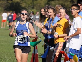 Villanova's Ashley Maguire is cheered by others while winning the WECSSAA junior girls' 5km cross-country race at Malden Park on Oct. 18, 2017.