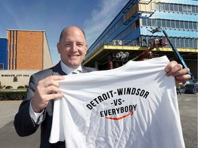 Windsor Mayor Drew Dilkens proudly displays his custom T-shirt for the Detroit-Windsor bid to land Amazon's second headquarters while arriving at City Hall on October 19, 2017.