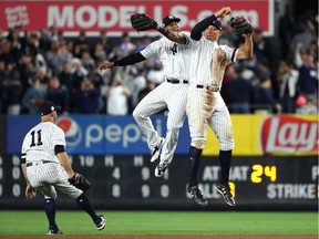 Aaron Judge #99 of the New York Yankees celebrates with Aaron Hicks #31 and Brett Gardner #11 after defeating the Minnesota Twins in the American League Wild Card Game at Yankee Stadium on October 3, 2017 in the Bronx borough of New York City. The New York Yankees defeated the Minnesota Twins with a score of 4 to 8.