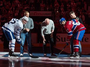 Tyler Bozak of the Toronto Maple Leafs and Max Pacioretty of the Montreal Canadiens join the president of the UFC, Dana White, centre, Georges St-Pierre, left, and UFC middleweight champion Michael Bisping, right, for the ceremonial puck drop at the Bell Centre on Saturday, Oct. 14, 2017.