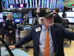 A trader wears a hat reading Dow 23,000 on the floor of the New York Stock Exchange on Oct. 18, 2017 in New York City. The Dow Jones Industrial average closed at 23,157.60, the first time it has ever closed above 23,000.