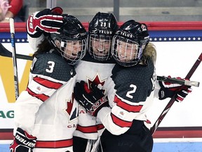 Marie-Philip Poulin, centre, of Canada celebrates with teammates Jocelyne Larocque, left, and Meghan Agosta after scoring against the United States during the third period at Agganis Arena at Boston University on Oct. 25, 2017 in Boston, Mass. Canada defeat the United States 5-1.