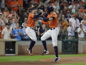 Houston Astros' Carlos Correa, right, celebrates his two-run home run with teammate Jose Altuve, left, during the first inning in Game 2 of baseball's American League Division Series against the Boston Red Sox on Oct. 6, 2017, in Houston.
