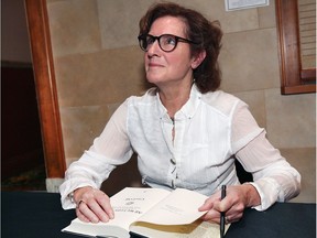 Journalist and author Carol Off, host of CBC Radio's As It Happens, signs a copy of her latest book, All We Leave Behind, during a Windsor BookFest appearance, Oct. 21, 2017, at the Capitol Theatre.