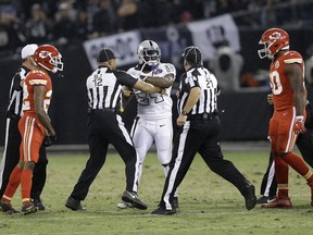 In this Oct. 19, 2017, photo, Oakland Raiders running back Marshawn Lynch (24) makes contact with back judge Greg Steed (12) during the first half of an NFL football game between the Raiders and the Kansas City Chiefs in Oakland, Calif., on Oct. 19, 2017. Lynch was ejected after the play.