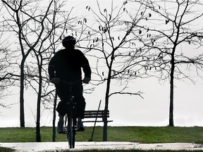 A cyclist is silhouetted against some bare trees as he makes his way along the Ganatchio Trail in this November 2006 photo.