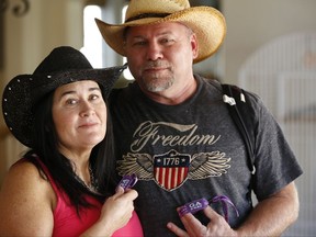 In this Friday, Oct. 6, 2017, Country music fan Julie Hart and her boyfriend Mark Gay pose for a photo as they recount fleeing from the shooting at the Route 91 Harvest festival Sunday, Oct. 1, in Las Vegas, at her family home in Anaheim Hills, Calif. Hart and Gay rushed out onto the airport fence, running with a group of people across the runways towards the terminals on the other side of McCarran International Airport in Las Vegas, as they realized they were being riddled with bullets. (AP Photo/Damian Dovarganes)