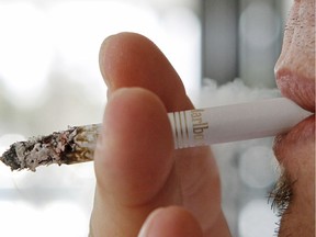 In this Feb. 7, 2011 file photo a person smokes a Marlboro cigarette, a Phillip Morris product, in Hialeah, Fla.