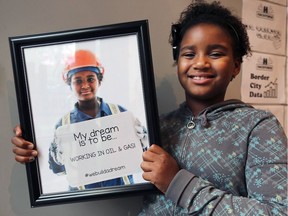Aletha Nsiah-Nelson, 9, poses with her photo during the event. The #IDreamtoBe photo campaign Wednesday, October 11, 2017, at the Windsor Hackforge location in downtown Windsor.