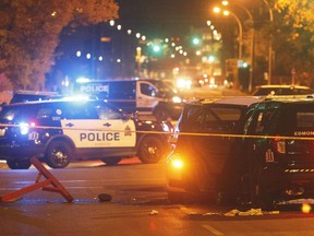 Police investigate the scene where a car crashed into a roadblock in Edmonton, Sept. 30, 2017. An Edmonton officer was stabbed and four other people injured when they were hit by a rental truck fleeing police. A 30-year-old Somali refugee is facing attempted murder charges.
