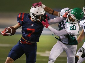 Holy Names' Mike Herzog, left, stiff arms Herman's Domenic Loyuk during the high school senior boys' football  game at the University of Windsor's Alumni Stadium on Oct. 6, 2017. Holy Names won the game 39-23.