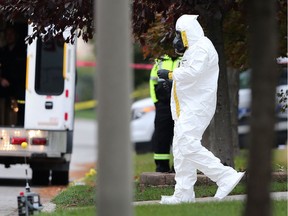 An official wearing a hazmat suit carries out an item from a home in the 2600 block of Gem Avenue on Friday, oct. 27, 2017.