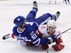 Toronto Maple Leafs defenceman Jake Gardiner (51) falls over Detroit Red Wings centre Dylan Larkin (71) during third-period NHL hockey action in Toronto on Oct. 18, 2017.