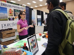 Mollie Charron, human resources coordinator with Pure Hothouse Foods Inc. in Kingsville, speaks with job seekers at a job fair at the WFCU Centre on Friday, Oct. 13, 2017.