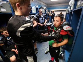 Ethan MacKinnon, left, helps football team manager Josh Marier with his shoulder pads before Villanova's football game against Herman on Oct. 26, 2017.