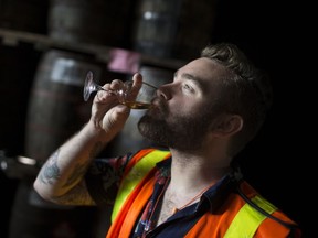 Brock McLaughlin, from Brockstar Gaming in Toronto, takes a drink of 20-year-old whisky at the J.P. Wiser's aging warehouse during a tasting tour, Oct. 4, 2017.