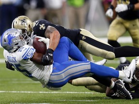 New Orleans Saints free safety Vonn Bell, below, and middle linebacker Manti Te'o, top, tackle Detroit Lions running back Theo Riddick (25) in the second half of an NFL football game in New Orleans, Sunday, Oct. 15, 2017.