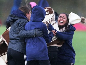 Massey's midget girls runners celebrate their team victory at the SWOSSAA cross-country championships at Malden Park in Windsor on Oct. 25, 2017.