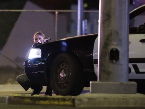 A police officer takes cover behind a police vehicle during a shooting near the Mandalay Bay resort and casino on the Las Vegas Strip on Oct. 1, 2017, in Las Vegas.