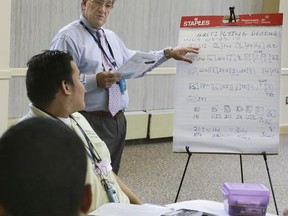 Nikolas Kinas, standing center, director of the HOPE program at the Hebrew Home at Riverdale, in New York, teaches a mathematics class to students in the program at the facility, Thursday, May 25, 2017. A decade ago, Kinas was clocking 16-hour days on Wall Street as a portfolio manager and trader when he sought more meaning in his work. He went back to school for a master's in special education, teaching high school math and science for six years before arriving at the Hebrew Home two years ago. The career change has amounted to a "rebirth" for him, the 58-year-old says. "These kids saved me in a lot of ways," he says. "They've taught me as much as I've taught them." (AP Photo/Richard Drew)