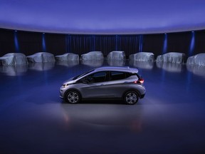 This photo provided by General Motors Co. shows a Chevrolet Bolt, surrounded by nine electric and fuel cell vehicles covered by tarps. On Monday, Oct. 2, 2017, GM announced the company will produce two new electric vehicles on the Bolt underpinnings in the next 18 months and 20 electric and hydrogen fuel cell vehicles by 2023.