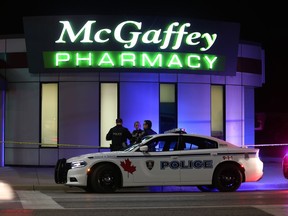 Windsor Police investigate a crime scene Wednesday night in front 
McGaffey Pharmacy near the corner of Tecumseh Road east and George Avenue in Windsor, Ontario on Oct. 18, 2017.