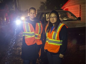 Heather Taylor, left, waste diversion specialist for the Essex-Windsor Solid Waste Authority, and her summer student, Eileen Chen, search for the correct recycling box in a dark alley in the early morning hours on Oct. 12, 2017, as part of the Gold Star Recycler Program.