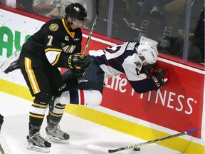 Nick Grima, left, of the Sarnia Sting sends William Sirman, of the Windsor Spitfires, into the boards during the first period of Sunday's game at the WFCU Centre. Dan Janisse