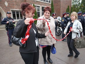 Wendy Luxford, left, is assisted by Sheila Davis and Patti Asseltine, right, both of Allstate Insurance, during a ribbon-cutting ceremony for MADD Windsor and Essex County Red Ribbon Campaign launch at Kennedy high school on Thursday. Luxford lost her brother in July 2015 following a fatal crash involving alcohol. Allstate Insurance has been a longtime supporter of MADD and Red Ribbon.