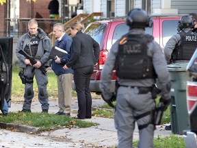 Windsor police ESU members and detectives speak with a person sitting inside a van near 356 Josephine Ave. on Nov. 6, 2017. Two arrests were made relating to a weekend homicide.