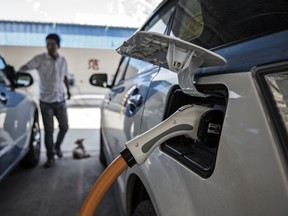 A plug is connected to the socket of a BYD Co. E6 electric taxi being charged at a charging station in Taiyuan, Shanxi province, China. BYD will open an electric-truck plant in Ontario next year.