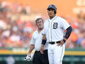 Miguel Cabrera of the Detroit Tigers leaves the game with trainer Kevin Rand during the fourth inning of the game against the Toronto Blue Jays on July 3, 2015 at Comerica Park in Detroit.