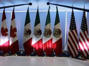 National flags representing Canada, Mexico, and the U.S. are lit by stage lights at the North American Free Trade Agreement, NAFTA, renegotiations, in Mexico City, Sept. 5, 2017.