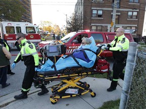 Paramedics prepare to load an ambulance with a resident of the apartment building at 16 and 30 Ellis St. East on Nov. 8, 2017.