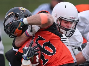 Danny Byrne, left, of L'Essor gets tackled by Max Mulvey of the Belle River Nobles during Thursday's WECSSAA AA football final on Thursday at the University of Windsor's Alumni Field.
