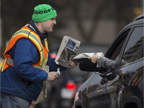 Andy Zanini sells the Goodfellows Edition to a motorist at the intersection of Ouellette Avenue and Tecumseh Road on Nov. 23, 2017.  Forty-three per cent of the Windsor Goodfellows funding comes from the newspaper drive and 83 per cent of all the money raised is spent on families and individuals in need. There are 600 volunteers on the street hawking newspapers for three days to raise donations and 12,350 boxes of food are handed out through the Goodfellows food bank and as Christmas boxes.